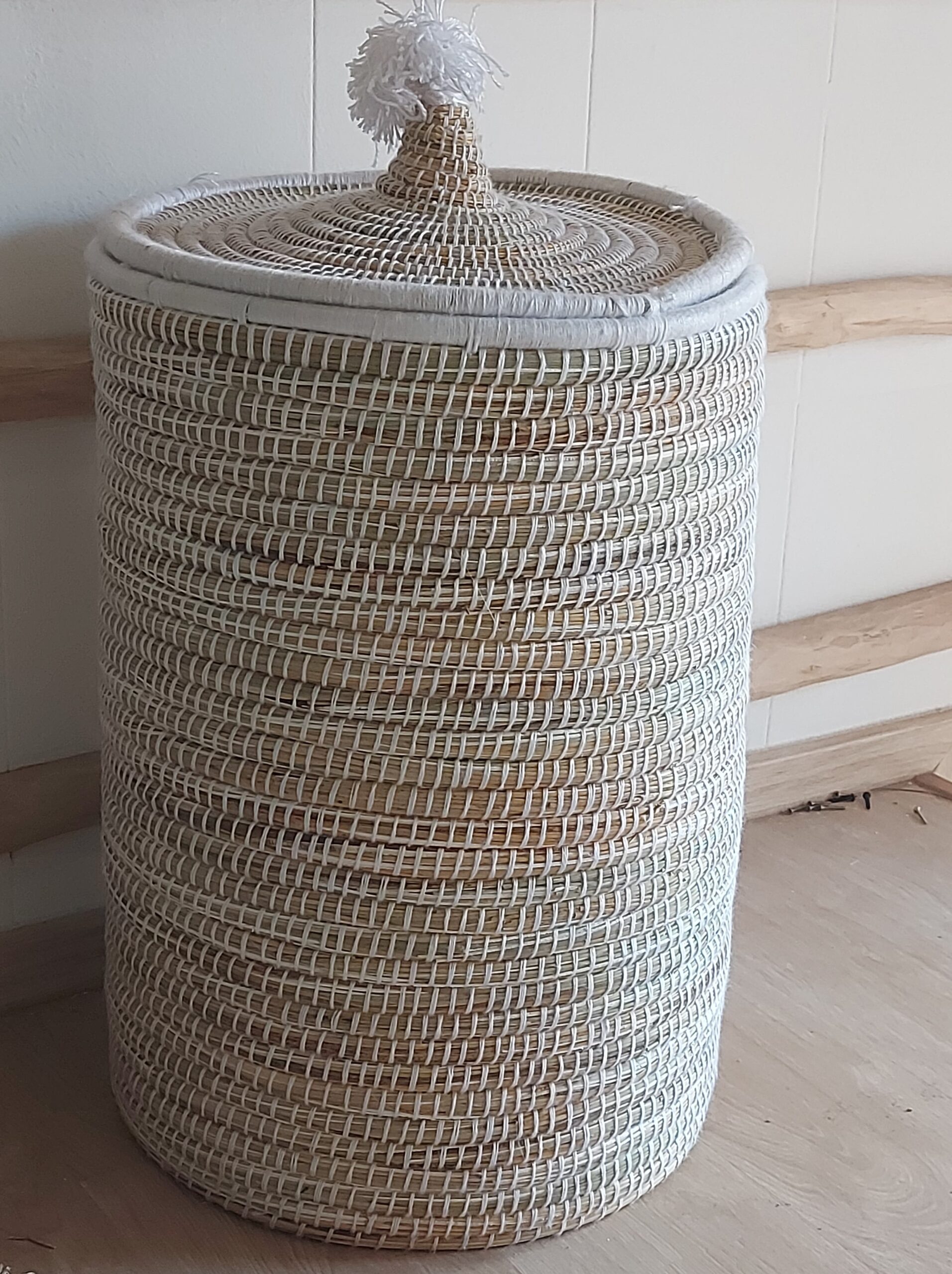 High wicker basket with white rope and pom